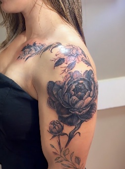 Tatuagem de flores e folhas no ombro e braço, por Alexandre Cunha.