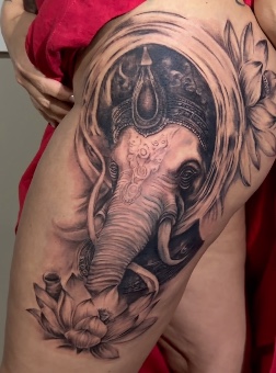 Tatuagem de Ganesha com flor de lótus na coxa, por Alexandre Cunha.